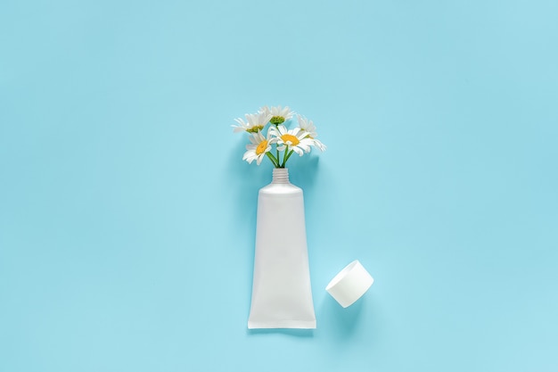 Ramo de flores de manzanilla de cosméticos, tubo blanco médico para crema, pomada, pasta de dientes u otro producto