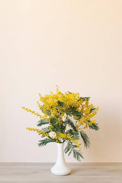 Ramo de flores de mimosa amarillas en un jarrón Concepto del día de la mujer o de la madre