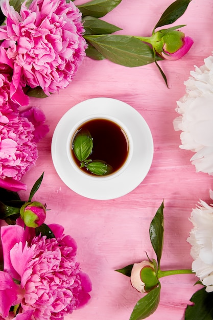 Ramo de flores de peonía y taza de café