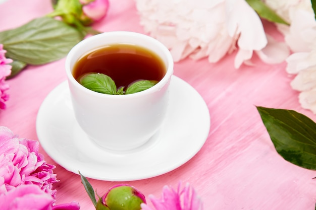 Ramo de flores de peonía y taza de café