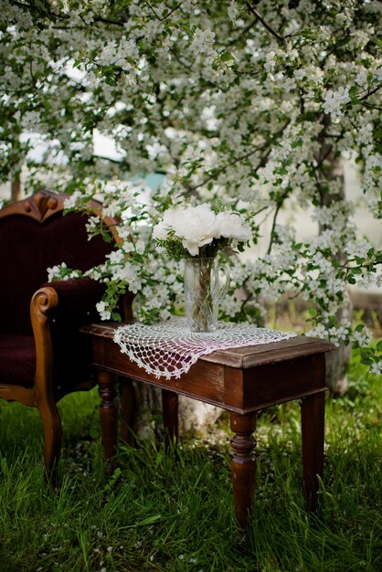 Ramo con flores de peonías blancas sobre la mesa en el jardín