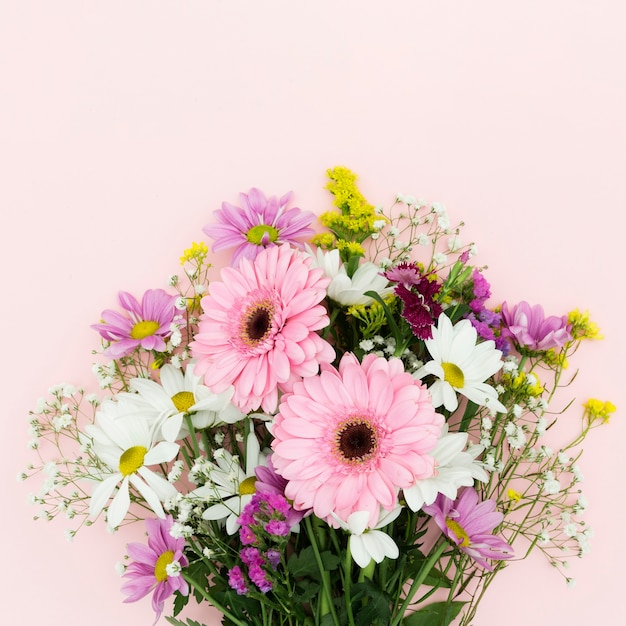 Foto ramo de flores planas sobre fondo rosa