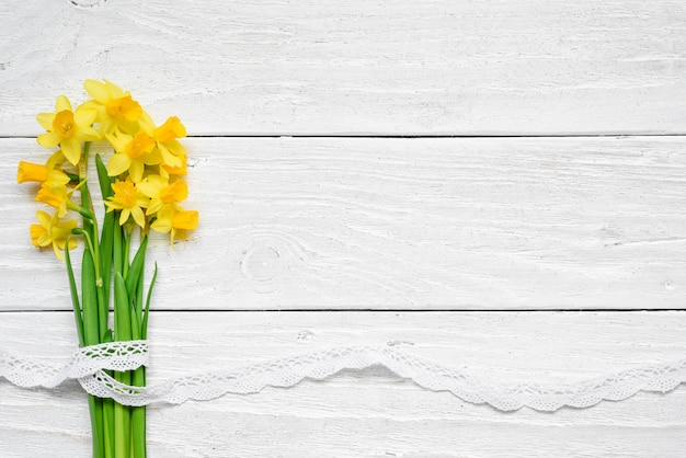 Ramo de flores de primavera de narcisos amarillos sobre mesa de madera blanca