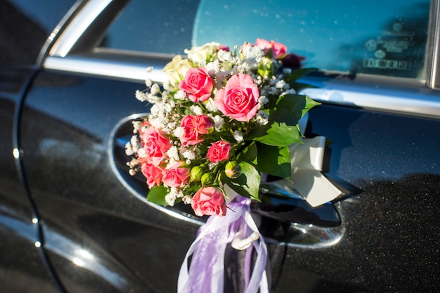 Un ramo de flores en la puerta de un coche.