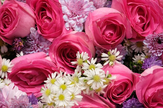 Un ramo de flores rosas con flores blancas en el centro.