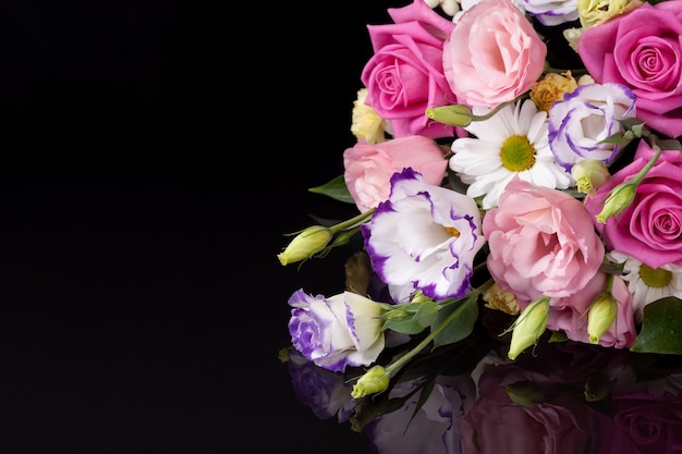 Un ramo de flores de rosas, lisianthus, margaritas, crisantemos con un reflejo