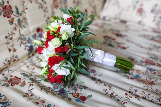 Ramo de flores de rosas rojas y blancas en el sofá