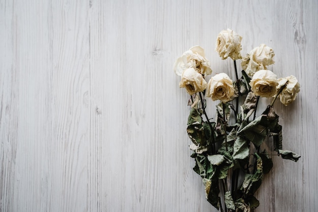 Ramo de flores secas Composición de flores hecha de rosa seca sobre fondo blanco de madera Espacio de copia de vista superior plana Lugar para texto y diseño