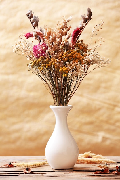 Foto ramo de flores secas en un jarrón sobre un fondo colorido