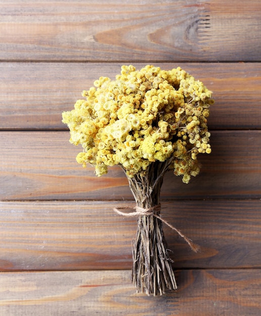 Ramo de flores secas sobre fondo de tablones de madera