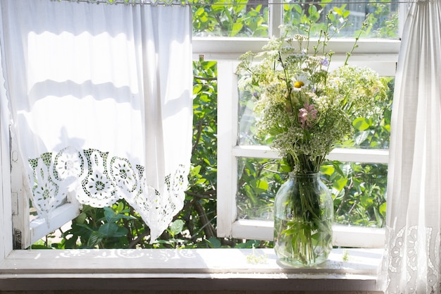 Foto ramo de flores silvestres en el alféizar de la ventana