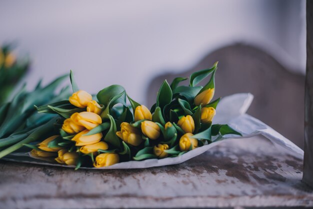 Ramo de flores de tulipanes amarillos en una mesa de madera