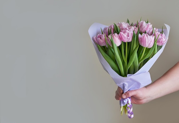 Ramo de flores tulipanes rosas en mano Entrega de flores Feliz cumpleaños Fondo primavera Día de las madres