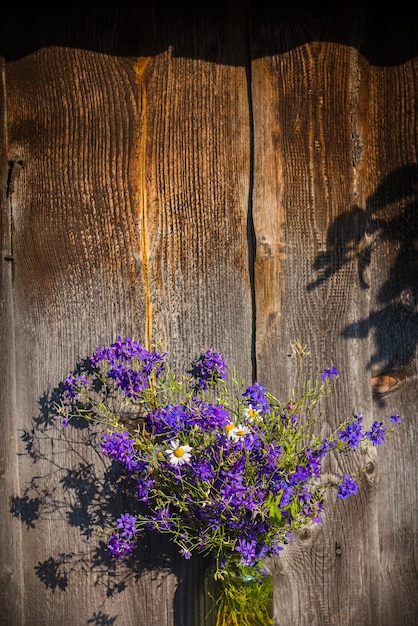 Ramo de flores de verano azul sobre fondo de madera
