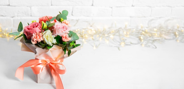 Ramo de flores de verano sobre un fondo blanco con hermoso bokeh, espacio libre para texto. Ramo de banner de rosas rosadas para sitio web. Foto de alta calidad