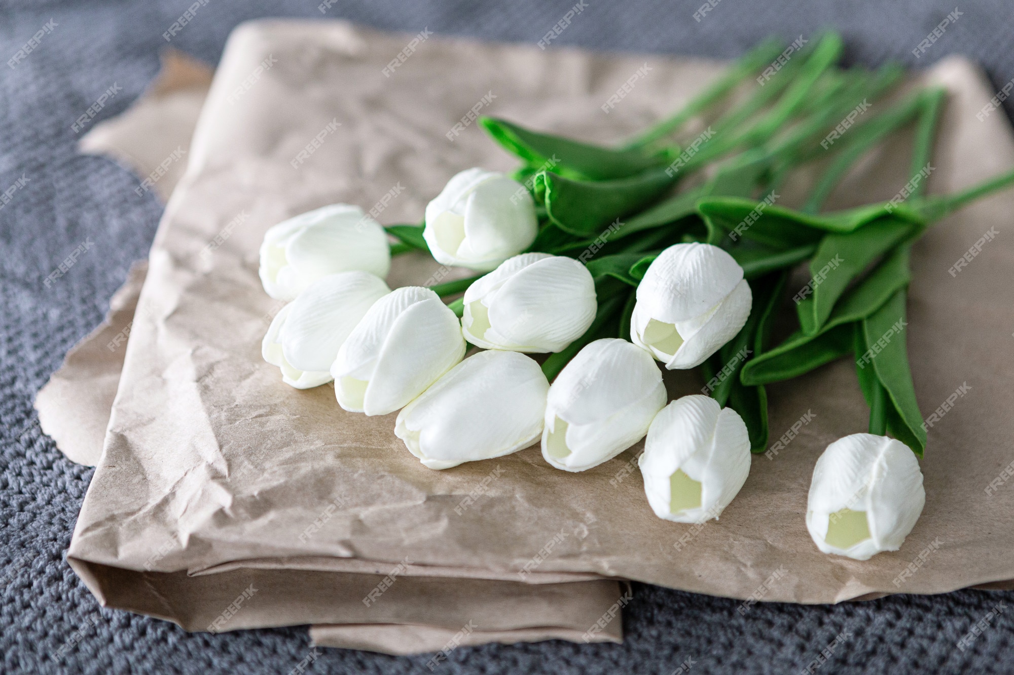 Ramo fresco de tulipanes blancos sobre papel reciclado sobre fondo gris |  Foto Premium