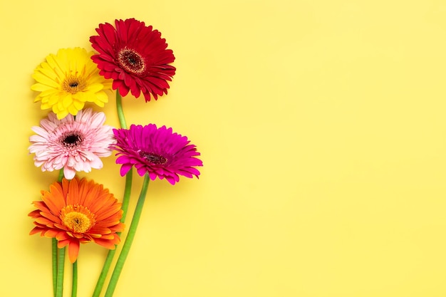 Ramo de gerberas sobre fondo amarillo Vista superior Lay Flat Tarjeta de felicitación de vacaciones