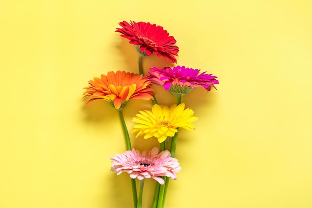 Ramo de gerberas sobre fondo amarillo Vista superior Lay Flat Tarjeta de felicitación de vacaciones