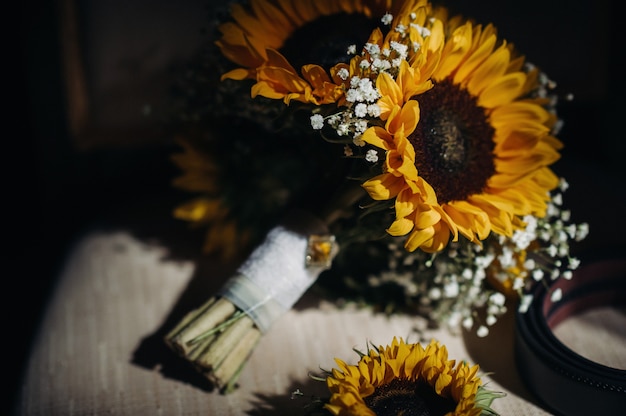 Un ramo de girasoles de boda se encuentra en una silla antigua