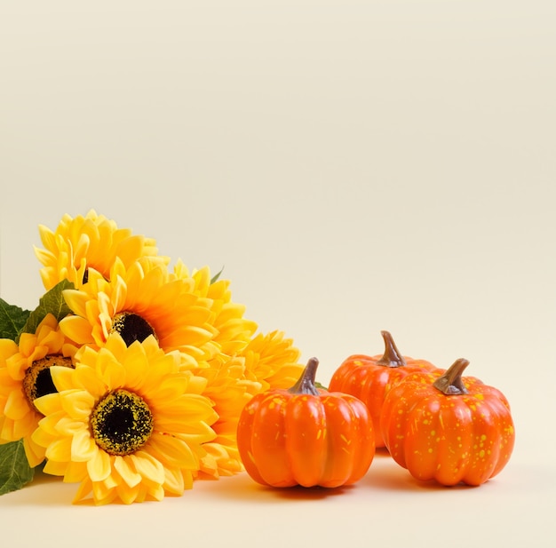 Ramo de girasoles y calabaza sobre un fondo beige