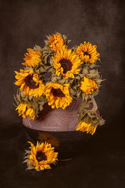 Un ramo de girasoles de otoño en un jarrón de arcilla.