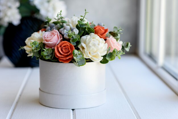 Ramo de hermosas flores rosas brillantes en una caja de cartón cilíndrica de regalo