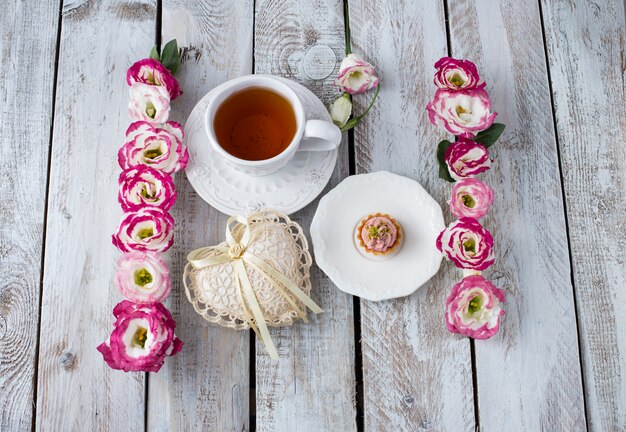 Ramo de hermosas flores con taza de té y corazón de encaje. Fondo de vacaciones: 8 de marzo, día de San Valentín, día de la madre, boda, compromiso