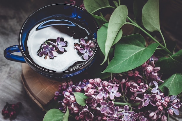 un ramo de hermosas lilas rosa púrpura y una taza de té caliente