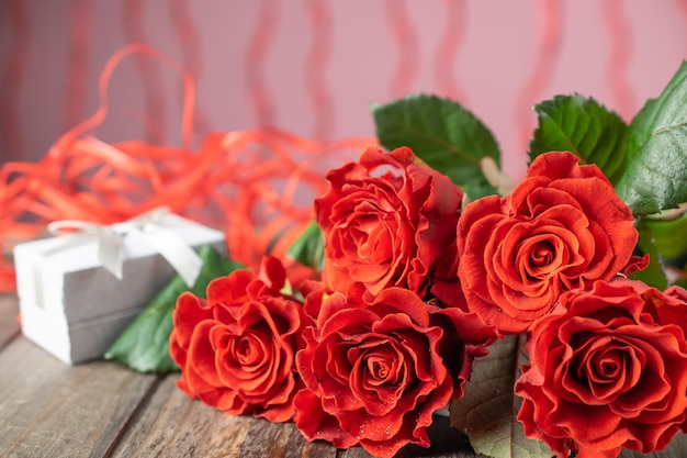 Foto ramo de hermosas rosas rojas y una caja de regalo