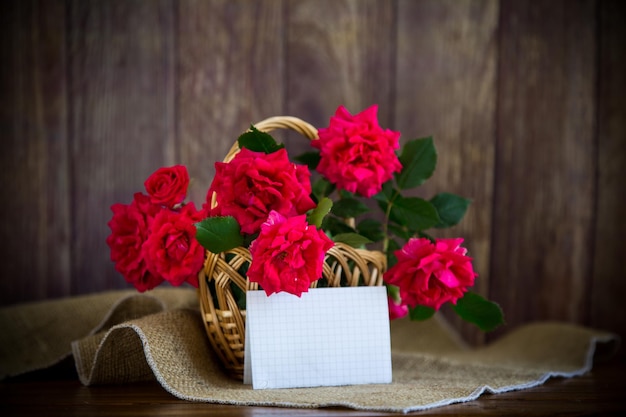 Un ramo de hermosas rosas rojas en una canasta en la mesa