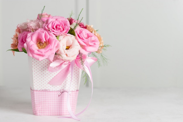 Ramo de hermosas rosas rosadas y eustomas en una caja