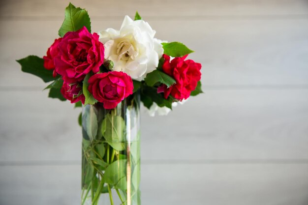 Ramo de hermosos blancos y rojos sobre una mesa de madera.