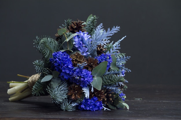 Ramo de invierno de ramas de abeto Nobil, jacintos azules y conos, concepto de regalo de invierno