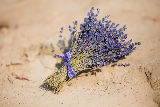 Ramo de lavanda atado con cinta sobre la arena