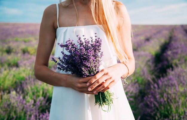 Ramo de lavanda en manos de una mujer con un vestido blanco