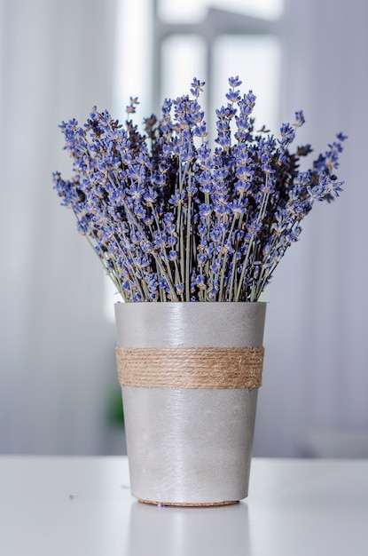 Foto un ramo de lavanda en un vidrio gris en una tabla de interior gris.