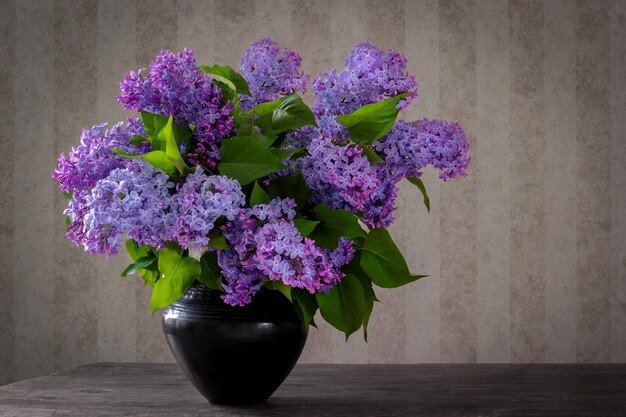 Un ramo de lilas en un jarrón negro