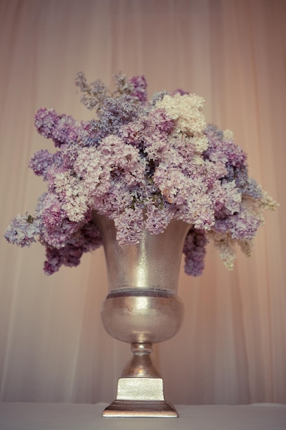 Ramo de lilas en jarrón de plata