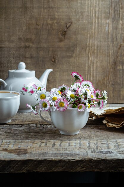 Foto ramo de margaritas comunes en una taza de té