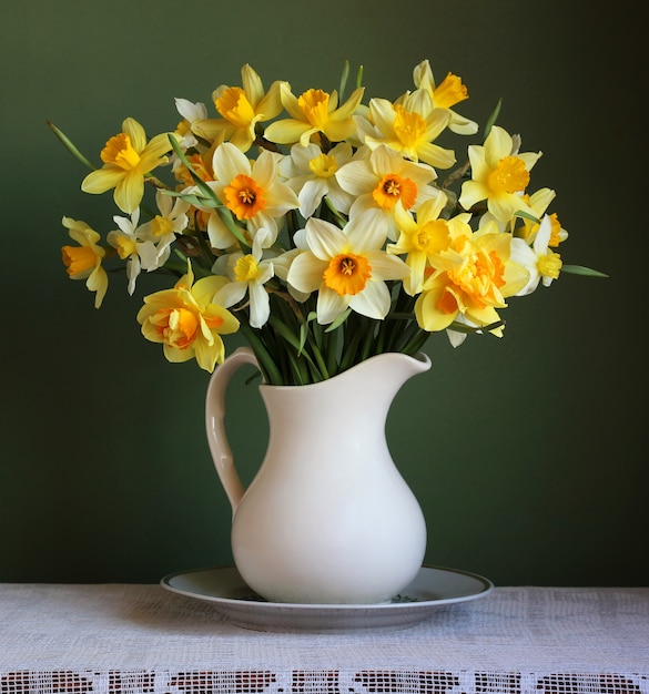 Ramo de narcisos de jardín amarillos en una jarra blanca