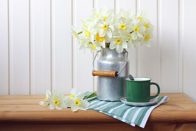 Un ramo de narcisos en una lata de aluminio sobre la mesa en el interior de la cabaña