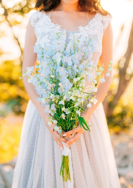 Ramo de novia de boda de delphinium azul en las manos