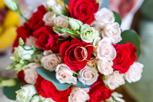 Ramo de novia brillante de rosas rojas y blancas de verano con anillos