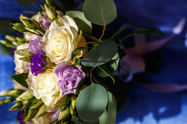 Ramo de novia brillante de rosas violetas blancas de verano con anillos de boda