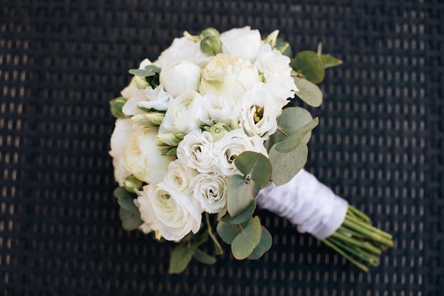 Ramo de novia clásico de rosas blancas sobre un fondo oscuro