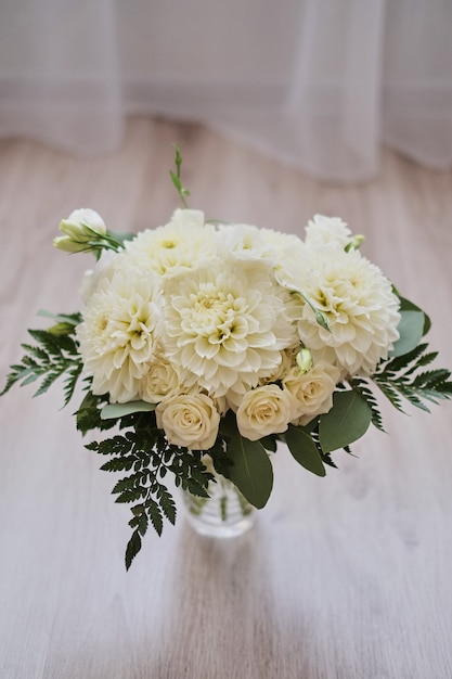 Ramo de novia de dalias sobre tablas de madera.