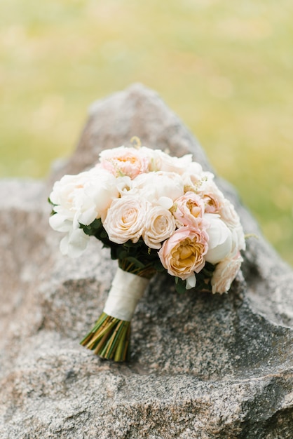 Un ramo de novia delicado se encuentra en una piedra