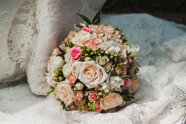 El ramo de novia se encuentra en el vestido de novia de penacho. Textura de vestido de novia. Las rosas son de color rosa y blanco.