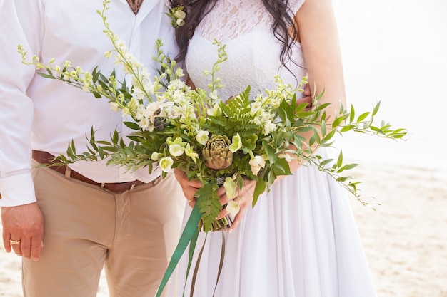 Un ramo de novia está en manos de la novia.