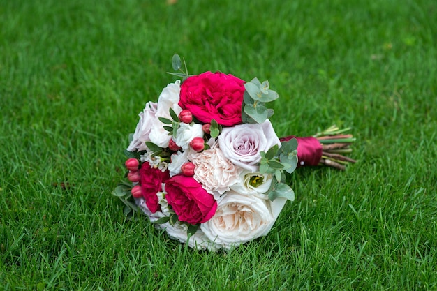 Ramo de novia de flores de color rojo brillante en la hierba